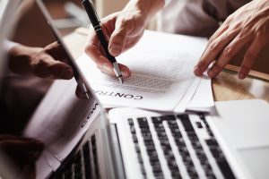 Hand of employee with pen before signing contract