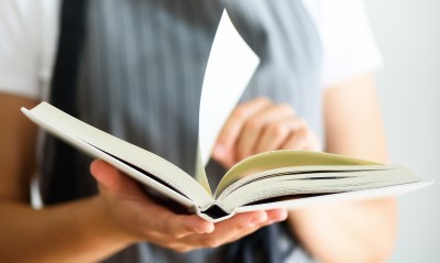 An open story book, with a page being turned by the reader.