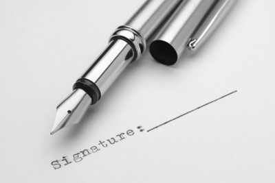 An uncapped fountain pen sitting on top of a contract awaiting a signature. Legally, that signature means everything.