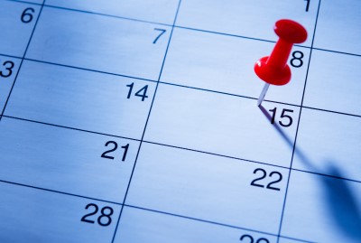 Red pin marking a date in a calendar.