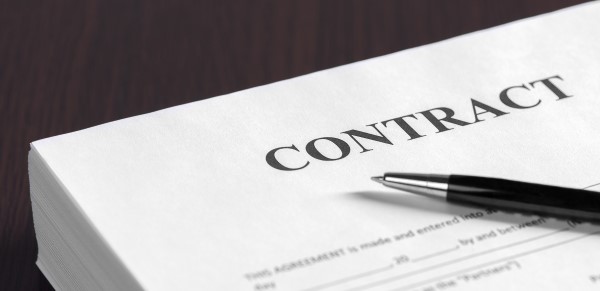 Close-up image of a contract. Don't do anything without the client signing one.